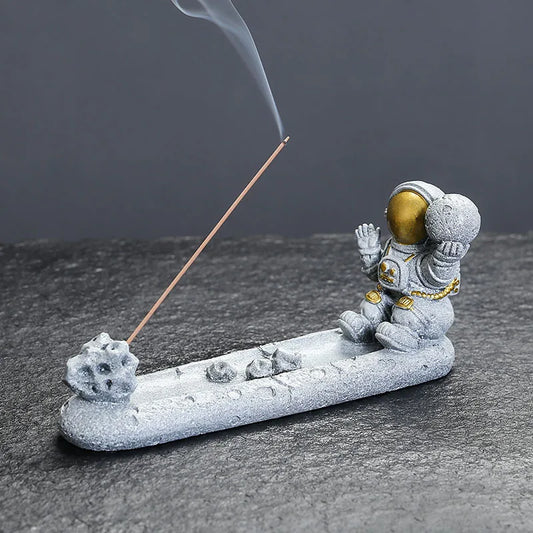 Incensario astronauta meditando em resina cinza, ideal para meditação e decoração sensorial


