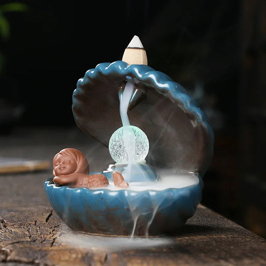 Incensário Cascata Oceano Azul em cerâmica com luz suave e design marinho. Ideal para meditação, relaxamento e decoração sensorial. Encontre paz e beleza no seu espaço.
